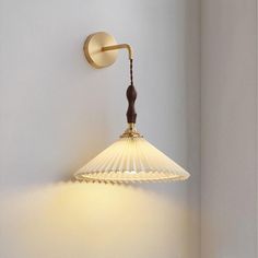 a wall light that is on the side of a wall with a lamp attached to it