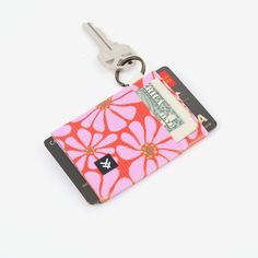 a pink and red flowered wallet with a keychain hanging from the front