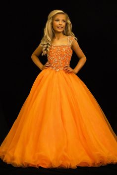 Sugar Kayne C146 Girls Pageant Dress. This lush pageant ballgown is made of flowy organza fabric. The top is embellished with semi sweetheart neckline and cap sleeves. Float on the stage in this full flowy pageant ballgown for girls and preteens. Colors: Turquoise, Orange Sizes: 2-16 (Sizes 2-6 do not have bust cups, Sizes 8-16 will have preteen size bust cups) Fabric: Organza, Mesh, Stretch Lining Baby Christening Outfit, Johnathan Kayne, Girls Communion Dresses, Girls Pageant Dresses, Christening Dress, Christening Gowns, Pageant Dress, Organza Fabric, Pageant Dresses