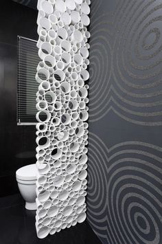 the toilet is next to a wall with circles on it