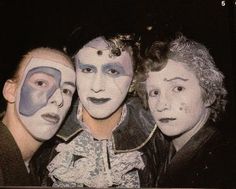 three people with painted faces pose for a photo