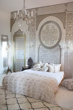 a large bed sitting under a chandelier in a bedroom