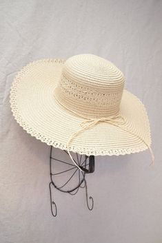 Vintage inspired wide brimmed straw hat. Hat features round crown, soft straw, and a matching ribbon trim along with lace trim. Inner crown features ties to adjust for head size. Product Details measurements: one size Brim- 4.72in Circumference- 23in material: straw imported Elegant Adjustable Crochet Hat For Vacation, Elegant Adjustable Crochet Hat For Spring, Elegant Crochet Hat With Curved Brim For Vacation, Elegant Crochet Hat With Curved Brim For Beach, Elegant Adjustable Wide Brim Crochet Hat, Elegant Crochet Hat For Spring Vacation, Adjustable Cream Wide Brim Straw Hat, Elegant Brimmed Crochet Beach Hat, Beige Adjustable Hat With Ribbon