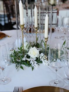 a table topped with lots of white flowers and candles