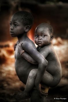 two young boys hugging each other in front of an image of the earth and sky