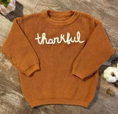 "Beautiful oversized hand embroidered knit sweater for kids. Our \"Thankful\" is hand written and available in the color white. Sweaters are brown in color and give off all the fall/thanksgivings vibes. The sweater is oversized." Cute Brown Crew Neck Sweater, Cute Brown Sweater For Fall, Embroidery Sweater Diy, Thanksgiving Vibes, Sweater Embroidery, Thanksgiving Sweater, Diy Thanksgiving, Embroidery Sweater, Etsy Ideas