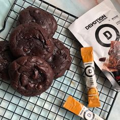 chocolate chip cookies on a cooling rack next to a bag of protein bars and an energy bar