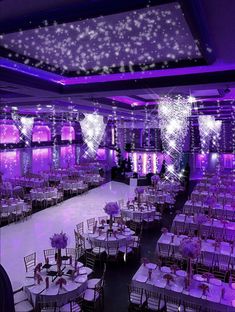 an empty ballroom with purple lighting and white linens