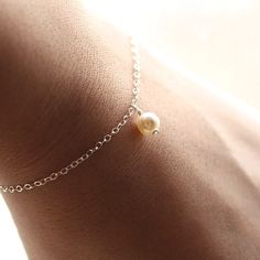 "The most simple & delicate everyday bracelet. A dainty Swarovski crystal light cream pearl (6mm) floats from the most dainty & shimmering sterling silver chain. Bracelet is completed with a round spring clasp. ♥Also available in gold fill: https://www.etsy.com/listing/104812683/dainty-everyday-gold-pearl-bracelet ★★Need help with your bracelet size? Please measure your wrist, and add 1/2 - 3/4 of an inch for a comfortable fit! ♥Your purchase will come thoughtfully packaged and ready for Everyday Delicate Sterling Silver Pearl Bracelet, Adjustable Delicate Sterling Silver Bracelet, Delicate Sterling Silver Pearl Bracelet As Gift, Minimalist Sterling Silver Pearl Bracelet For Wedding, Dainty Sterling Silver Bracelet For Anniversary, Dainty Sterling Silver Bracelets, Classic Sterling Silver Jewelry For Bridesmaids, Elegant Tiny Silver Jewelry, Minimalist Sterling Silver Bracelets For Bridesmaids