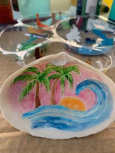 a glass plate with palm trees painted on it and other items in the back ground