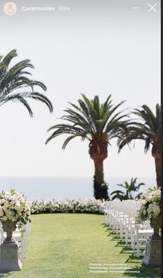 an outdoor ceremony setup with white chairs and palm trees in the background, overlooking the ocean