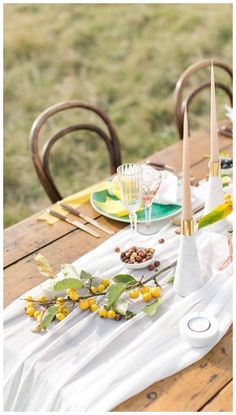 the table is set with plates, glasses and napkins for an outdoor dinner party