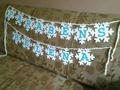 two decorative pillows sitting on top of a couch next to each other with snowflakes