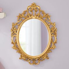 an ornate gold mirror hanging on the wall