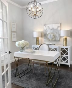 a white table and chairs in a room with a chandelier hanging from the ceiling