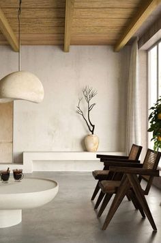 a living room filled with furniture and a large vase on top of a white table