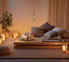 a bed with candles and pillows on top of it next to a potted plant