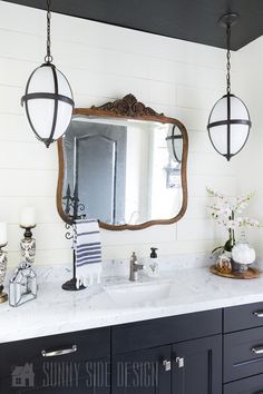 a bathroom vanity with two lights hanging over it