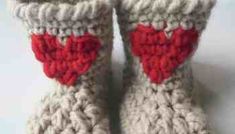 a pair of crocheted baby booties with a red heart