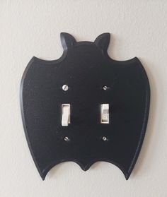 a black wall mounted light switch plate with an animal face on it's cover