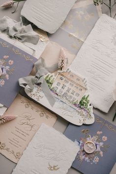 wedding stationery is laid out on top of each other, with flowers and ribbons