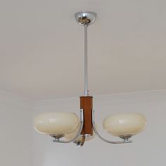 a chandelier hanging from the ceiling in a room with white walls and flooring