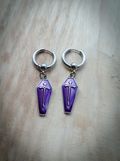 Stunning gothic style cross and coffin Huggie hoop earrings ⚰️ Unisex. Available in various colours ( see photos) Available as a single earring or as a pair. Huggie hoops are made of stainless steel and measure 17mm Coffin charms are made of enamel and measure 25mm Please don't hesitate to contact me with any queries or suggestions ☺️ Comes gift wrapped 💜 Gothic Purple Metal Jewelry, Gothic Surgical Steel Jewelry Gift, Gothic Surgical Steel Jewelry For Gifts, Handmade Gothic Piercings For Gift, Gothic Pierced Hoop Earrings As Gift, Gothic Surgical Steel Earrings As Gift, Gothic Hoop Earrings Gift, Gothic Hoop Earrings For Gift, Punk Style Small Hoop Jewelry Gift