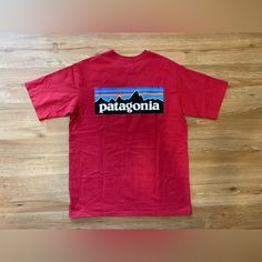 Add Some Eco-Friendly Style To Your Wardrobe With This Patagonia Men's P-6 Logo Responsibili-Tee T-Shirt In Sumac Red. The Short-Sleeved Tee Features A Solid Pattern With A Crew Neck And A Regular Fit, Making It A Comfortable Option For Everyday Wear. The Shirt Is Made From High-Quality Materials With Double-Sided Features And Accents, Including The Iconic Patagonia Logo. This Red Tee Is Perfect For Men Who Want To Show Off Their Love For The Outdoors While Maintaining A Stylish And Eco-Friendly Look. It's Available In Size Small And Is Sure To Become A Staple In Any Wardrobe. Red Short Sleeve T-shirt For Outdoor, Casual Red T-shirt For Outdoor Activities, Red Short Sleeve T-shirt For Outdoors, Red Tops With Graphic Print For Outdoor, Red Graphic Print Top For Outdoor, Red Crew Neck Top For Outdoor Activities, Red Cotton Tops For Outdoor Activities, Red Short Sleeve Tops For Outdoor, Red Cotton Tops For Outdoor