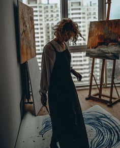 a woman is standing in front of an easel