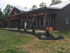 a house that is in the grass with some plants on it's front porch