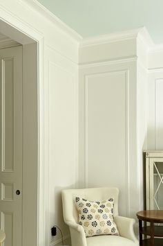 a white chair sitting next to a wooden table