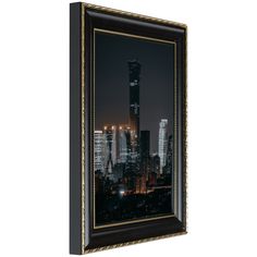 the city skyline is lit up at night in this framed art print, with gold trimming