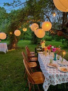 an outdoor dining area with paper lanterns hanging from the ceiling and table set for dinner