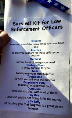 a person holding up a paper sign with the words survival kit for law enforcement officers