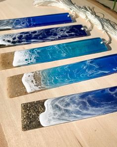 five different colored glass pieces sitting on top of a wooden table