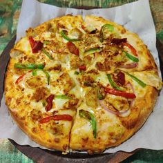 a pizza sitting on top of a cutting board covered in cheese and veggies