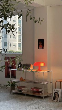 a living room filled with furniture next to a tall window and a plant in the corner