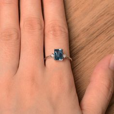 It is London blue topaz ring, the emerald cut topaz is about 6mm*8mm. The basic metal is sterling silver and plated with rhodium. To change the metal to a solid gold (white/rose) or platinum is also available, please ask for a quotation if you want. You can also go to my shop Home for more elegant rings: https://www.etsy.com/shop/godjewelry?ref=hdr_shop_menu Topaz is November birthstone. More topaz rings: https://www.etsy.com/shop/godjewelry?ref=hdr_shop_menu&section_id=20715039 Customizatio Classic Emerald-cut Topaz Ring In Sterling Silver, Emerald-cut Topaz Ring In 14k White Gold, Emerald Cut Topaz Ring In 14k White Gold, Modern Emerald Cut Topaz Promise Ring, Emerald Cut Topaz Ring Gift, Sterling Silver Emerald-cut Topaz Promise Ring, Sterling Silver Topaz Promise Ring, Emerald Cut, Emerald Cut Sterling Silver Topaz Promise Ring, Modern Emerald Cut Topaz Ring