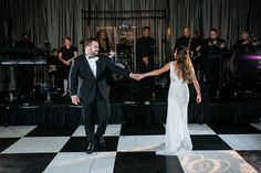 a bride and groom dance on the dance floor at their wedding reception in front of an orchestra