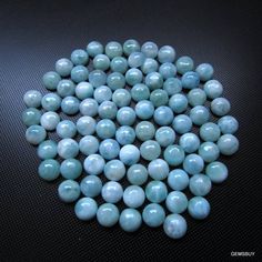 some blue and white marbles on a black surface