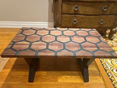 a wooden bench sitting on top of a hard wood floor next to a chest of drawers