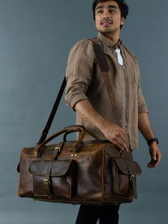 Trustpilot Our Goldman II buffalo leather duffel bag is the perfect weekend gateway partner for you because it is spacious, super stylish, and functional to carry all your travel necessities. This duffel makes a great carry-on for travel. Made from top-grain buffalo leather, this bag is handcrafted by skilled craftsmen to last for years. With a central compartment, this bag has enough space for carrying your clothes, shoes, accessories, etc. With 3 multiple pockets outside, you can better organi Rugged Large Capacity Duffle Bag For Travel, Leather Satchel Luggage For Trips, Large Capacity Leather Duffle Bag For Trips, Leather Travel Bag For Trip, Leather Satchel Duffle Bag For Trips, Rugged Travel Bag, Leather Weekender Bag For Travel, Rugged Travel Bag With Luggage Sleeve, Rugged Leather Duffle Bag For Travel