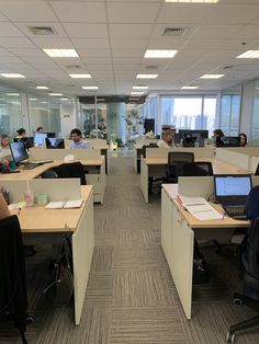 an office filled with people working on their laptops