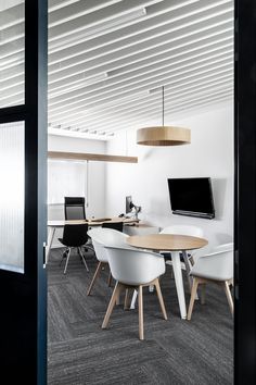 a conference room with white chairs and wooden tables