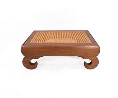 a small wooden table with perfored design on the top and bottom, against a white background