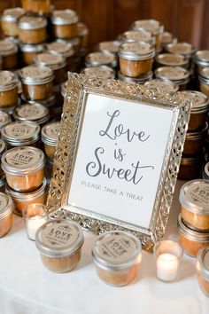 there is a sign that says love is sweet on the table next to some jars