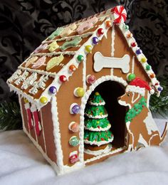 a decorated gingerbread house with a dog and christmas tree in the front door window