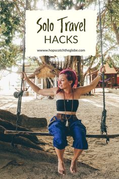 a woman sitting on a swing with the words solo travel hacks above her head