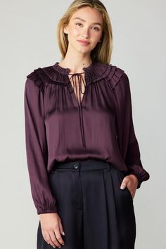 A gathered yoke and layered ruffles at the shoulders heighten the feminine charm of this breezy blouse. It's cut for a loose, relaxed silhouette and features a split neckline, self-tie detailing, and long sleeves with elasticized cuffs.  •Split neckline with self-tie •Gathered yoke •Ruffle trim •Long sleeves with elast Midnight Plum, Darkest Black Color, Woven Top, Black Charcoal, Ruffle Trim, Smocking, Plum, Ruffles, Work Wear