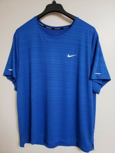 a blue nike shirt hanging on a hanger